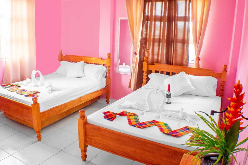 罗索拉弗拉姆博昂特酒店的配有粉红色墙壁的客房内的两张床
