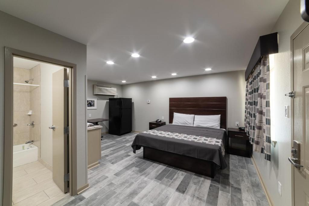 巴吞鲁日Budget Inn & Suites Baton Rouge的一间卧室配有一张床,浴室设有浴缸