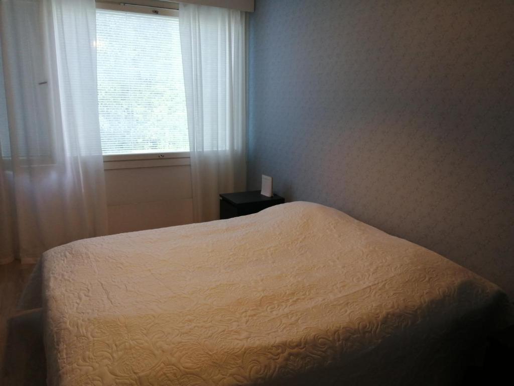 于韦斯屈莱Laajavuori Apartment的卧室配有白色的床和窗户。