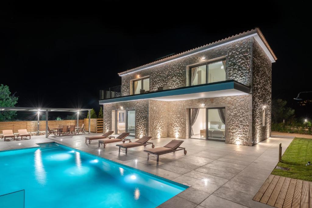 特拉佩扎奇Kefalonia Stone Villas - Villa Petros Kefalonica的夜间带游泳池的别墅