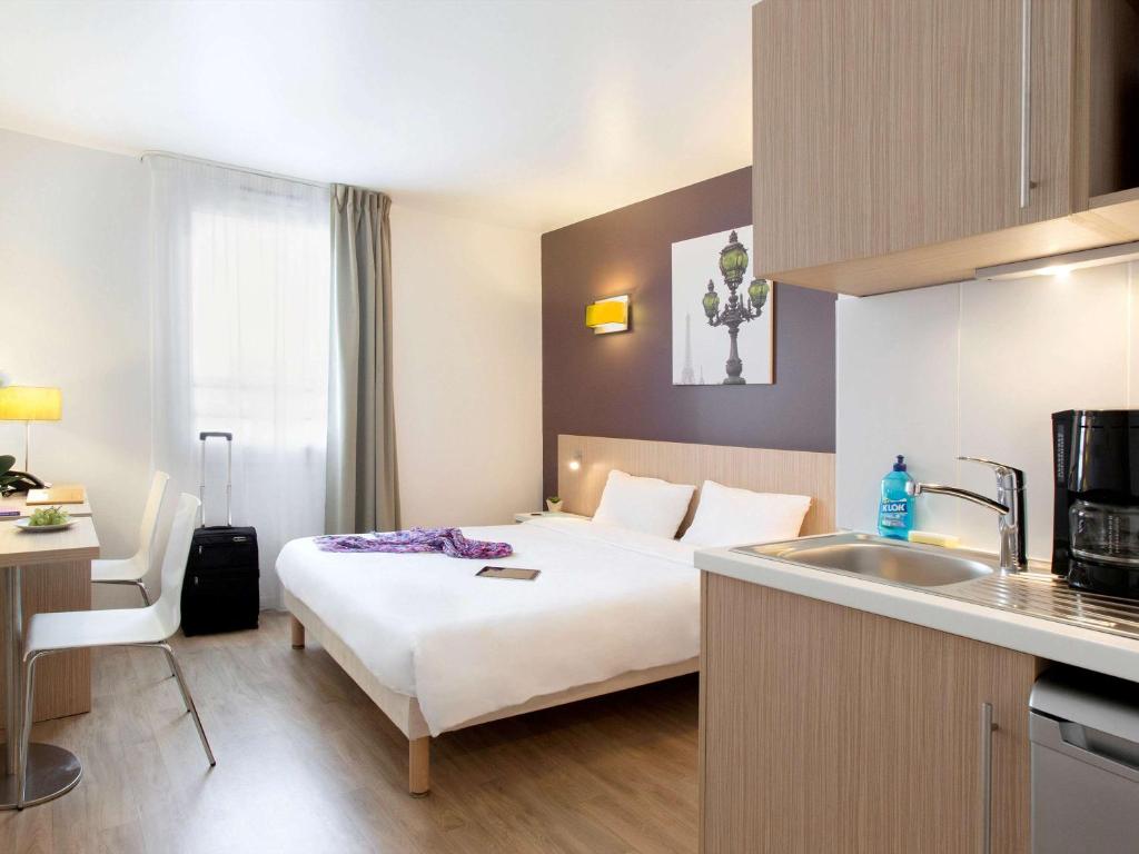 克利希巴黎克利希阿德吉奥阿克瑟斯公寓式酒店的酒店客房设有床和水槽