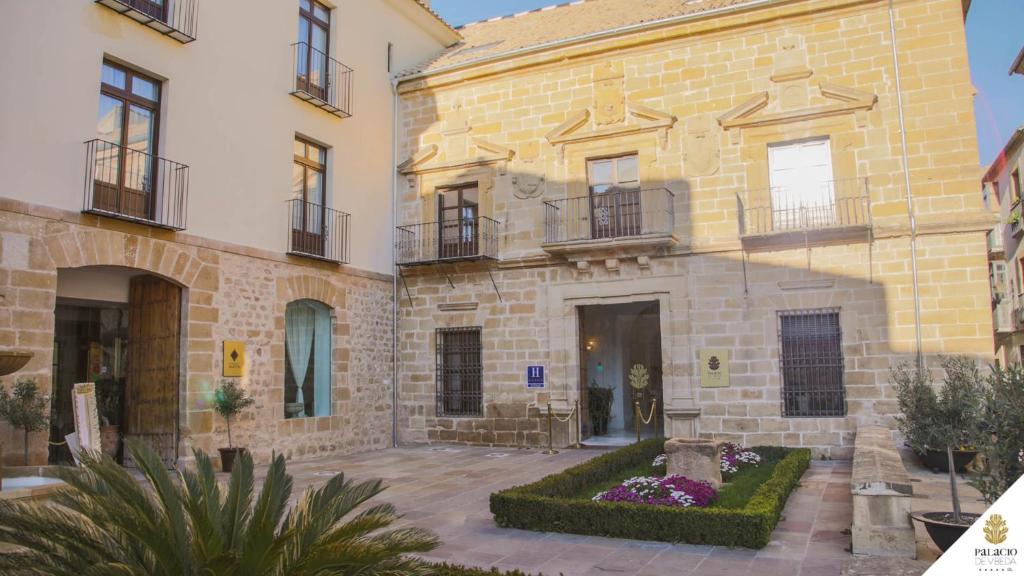 乌贝达Hotel Palacio De Úbeda 5 G.L的一座大型砖砌建筑,前面有一个庭院