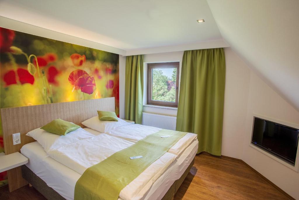 温德尔斯巴赫盖斯特豪弗林顿和威尔德克奥特酒店的一间卧室配有一张大床和电视