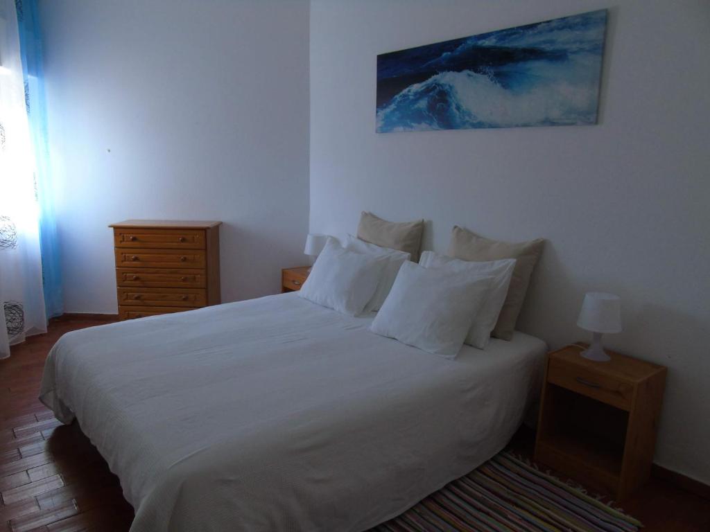 卢斯Cantinho Das Estrelas, Luz Lagos的一间卧室配有带白色床单和枕头的床。