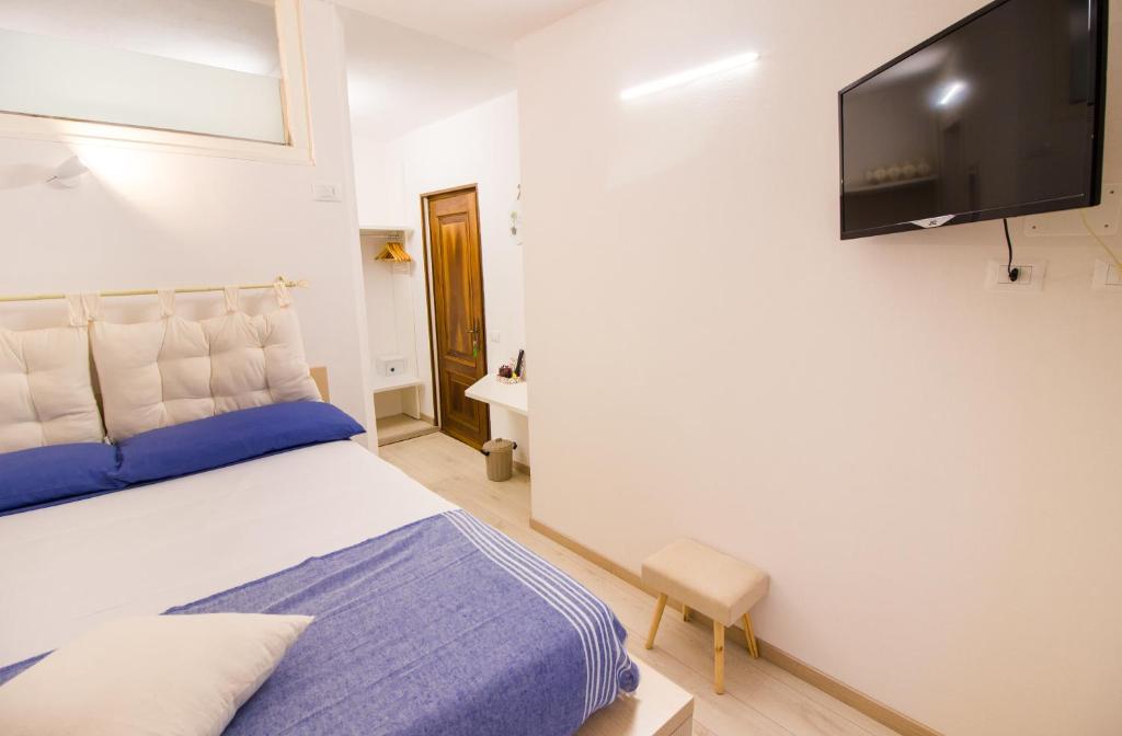 博尔戈马内罗Loft & Espace Maison 1706 Lago Orta的一间卧室配有一张床和一台平面电视