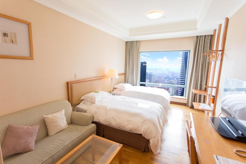 台中市金典绿园道商旅的酒店客房,设有两张床和一张沙发