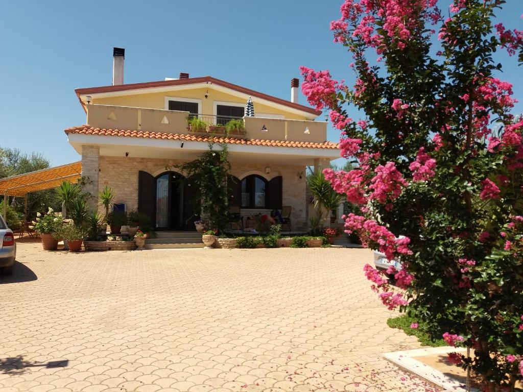 科拉托Villa Calendula的前面有粉红色花的房子