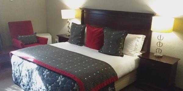 韦尔科姆Welkom Inn的酒店客房配有一张带枕头的大床