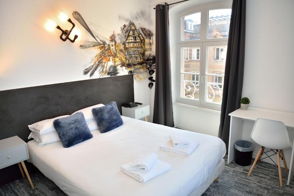 斯特拉斯堡Hotel des Arts - Centre Cathédrale的一间卧室配有一张带蓝色枕头的床和一扇窗户。