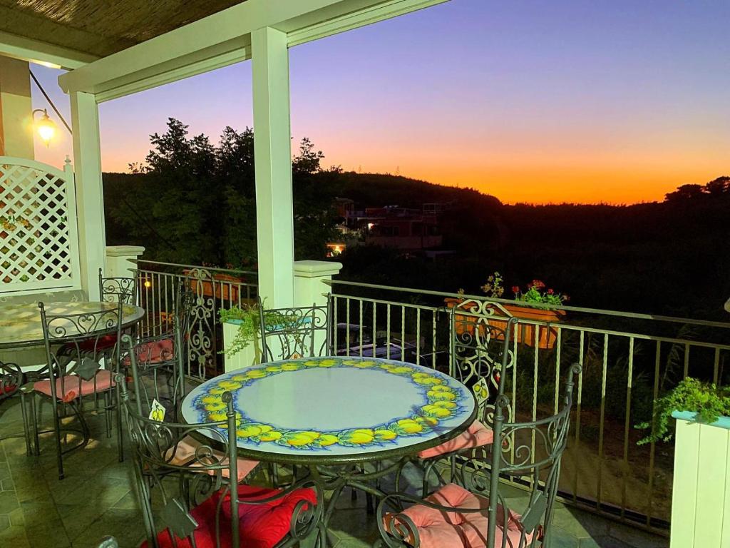 文托泰内Hotel Isolabella的阳台配有桌椅,享有日落美景。