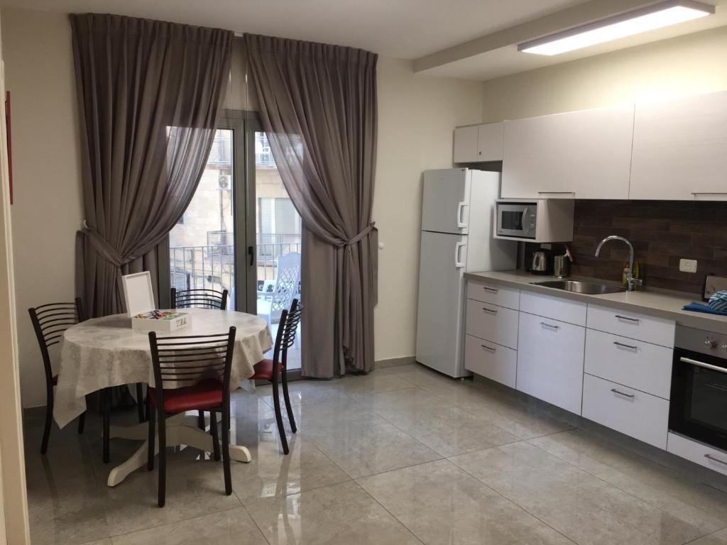 耶路撒冷西格尔耶路撒冷公寓的带桌椅的厨房、带桌子的厨房和厨房。