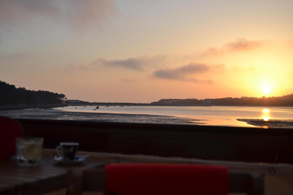 卡米尼亚Apartamento Foz do Rio Minho的海滩上的日落,配有桌椅