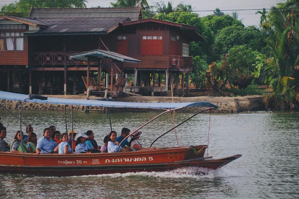 安帕瓦班桑湾民宿 的一群人乘着船在水里骑着