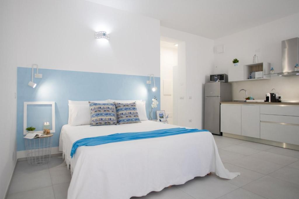托雷斯港Il Pescatore di Sogni的一间白色卧室,配有一张大床和一个厨房