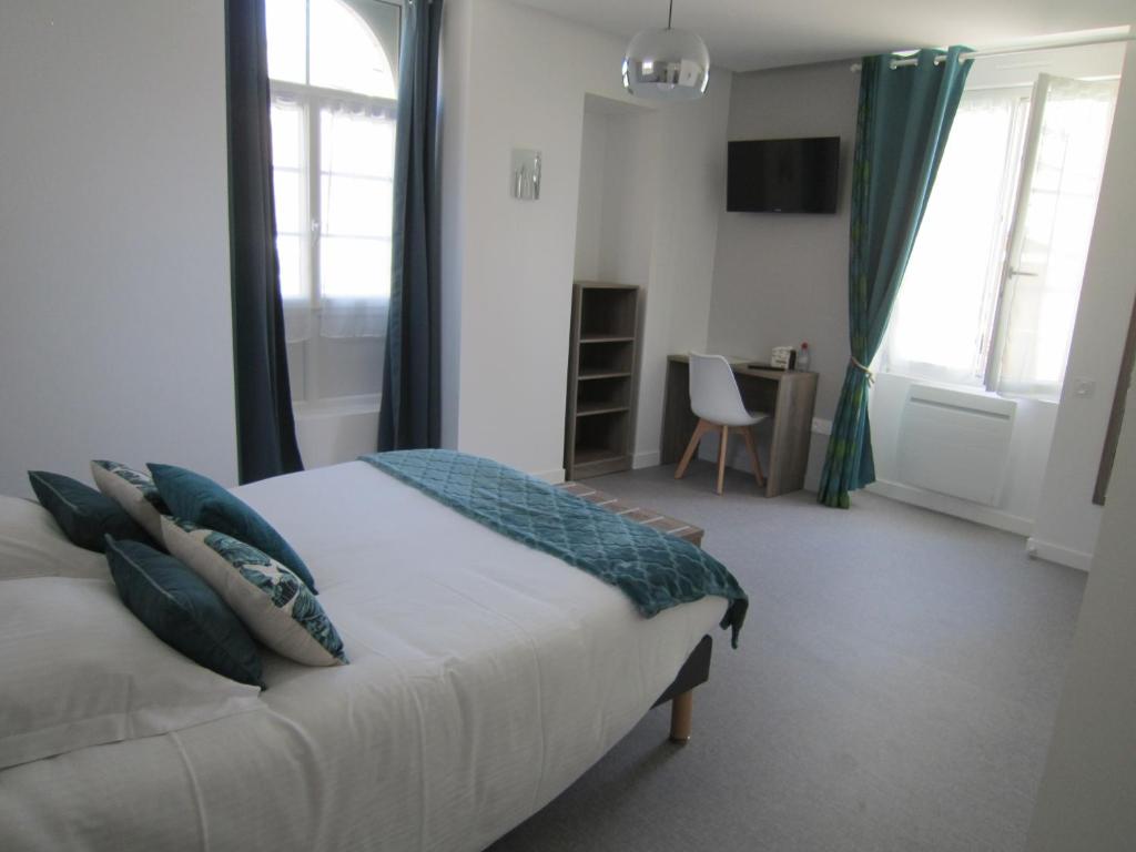 Ruillé-Froid-FondsLe Camélia的卧室配有带蓝色枕头的大型白色床