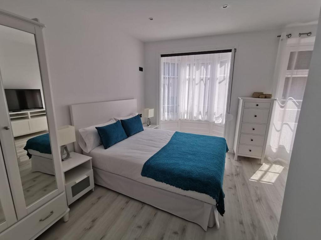希洪Begoña 18 Rest & Adventure的一间卧室配有一张大床和镜子