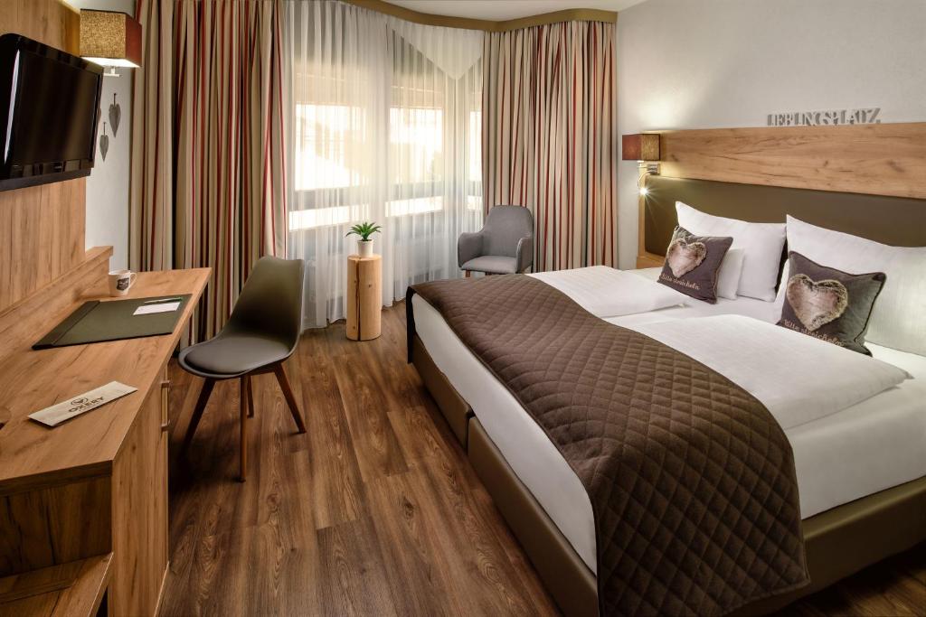 埃斯林根Neo Hotel Linde Esslingen的酒店客房设有一张大床和一张书桌。