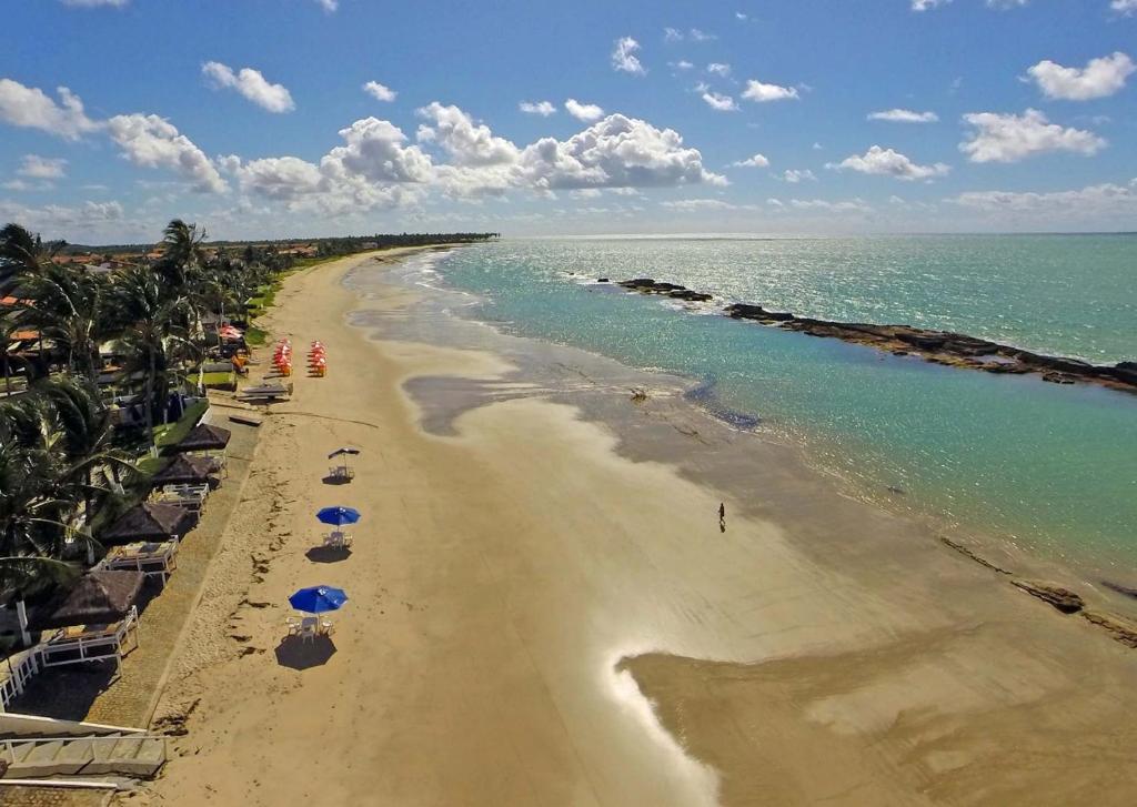 塔曼达雷Apart Marinas Tamandaré的享有海滩的空中景致,配有遮阳伞和海洋