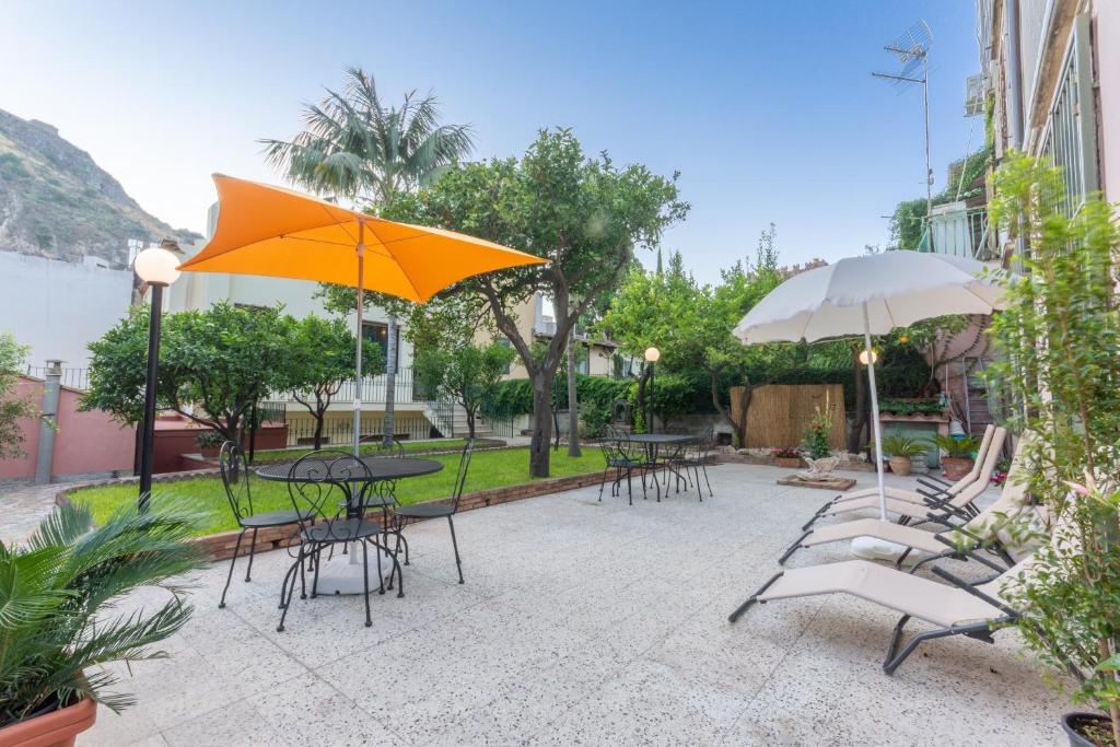 陶尔米纳Villa Valverde Apartments e B&B的一个带桌椅和遮阳伞的庭院