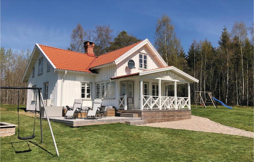SollebrunnLovely Home In Sollebrunn With Wifi的白色的小房子,设有门廊和秋千
