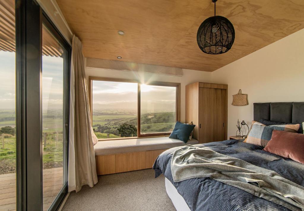 马丁伯勒Whitimanuka Retreat的一间卧室设有一张床和一个大窗户