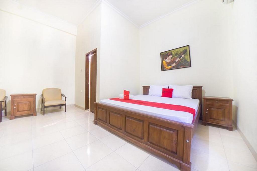 古邦RedDoorz near Nusa Cendana University的一间卧室配有一张床和一把椅子