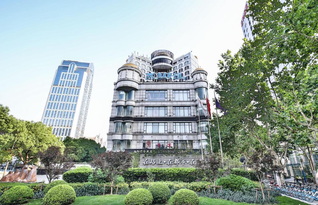 上海上海柏阳君亭酒店的一座高大的建筑,前面有一个公园