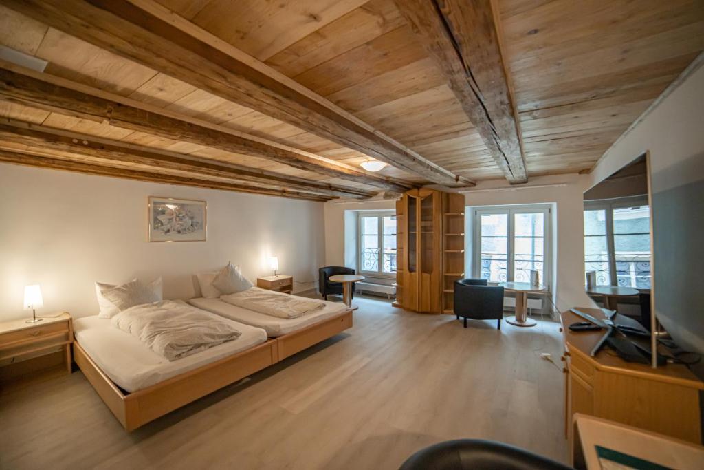 LaufenburgHotel Mokka Laufenburg的一间卧室配有一张床、一张书桌和一台电视。