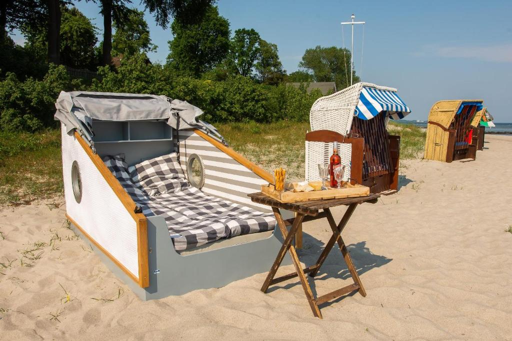 希尔克道夫Schlafstrandkorb Nr.2的海滩上的一张床铺和一张桌子