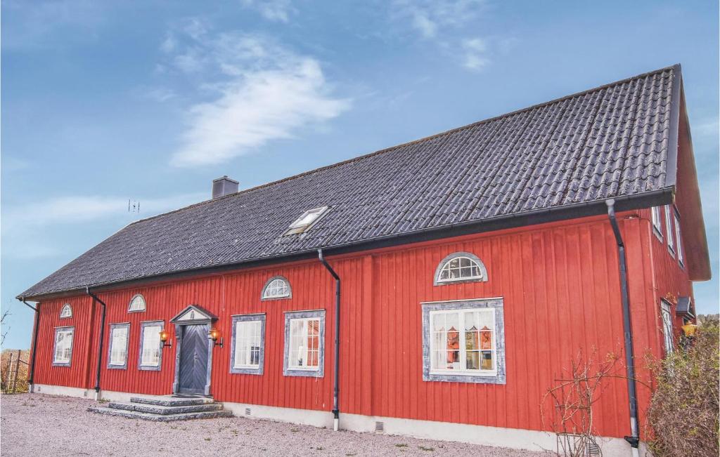 ÄlvstorpStunning Home In Tidaholm With 5 Bedrooms, Sauna And Wifi的黑色屋顶的红色谷仓
