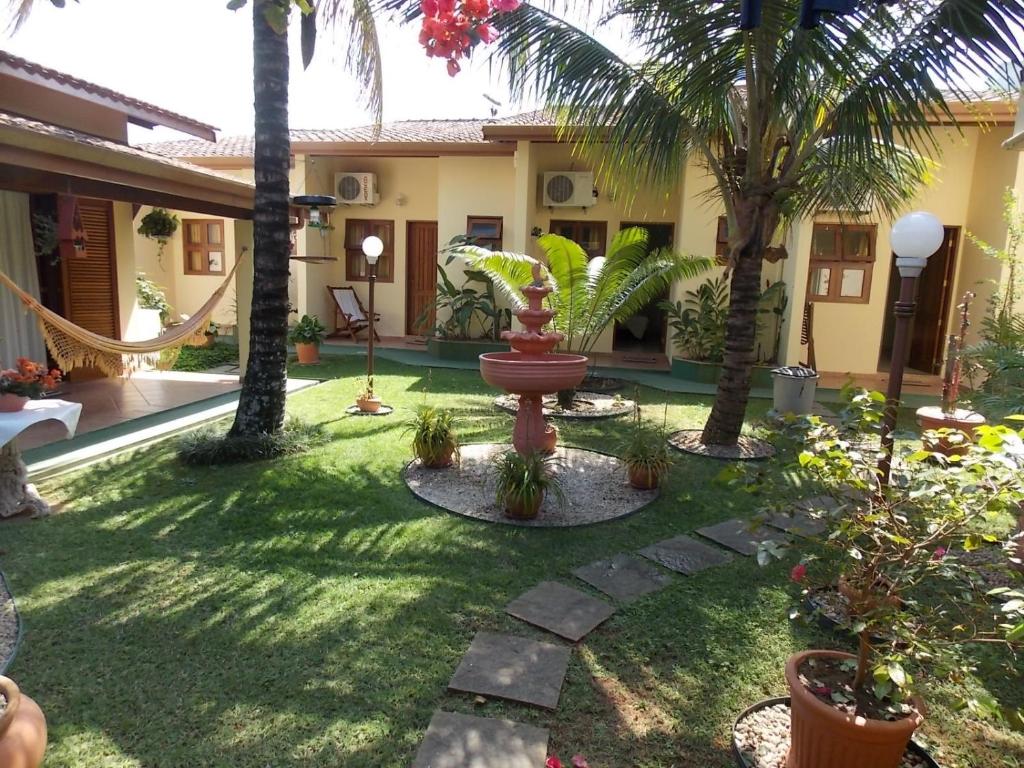 乌巴图巴Suítes Jardim dos Sonhos的庭院里种有棕榈树,设有喷泉