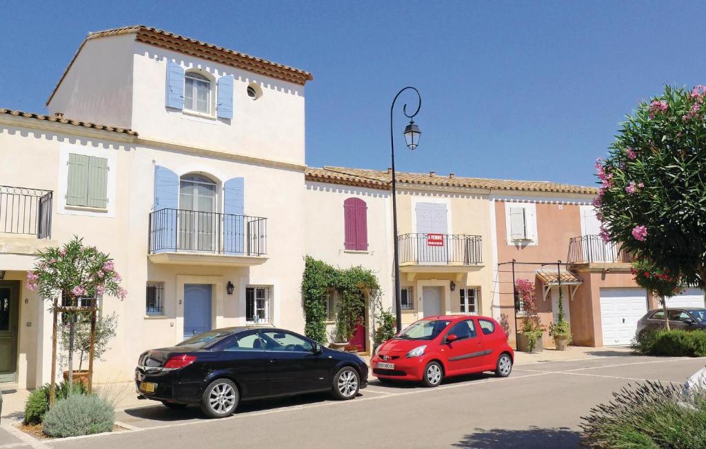 艾格-莫尔特Cozy Home In Aigues-mortes With Wifi的两辆汽车停在大楼前的停车场