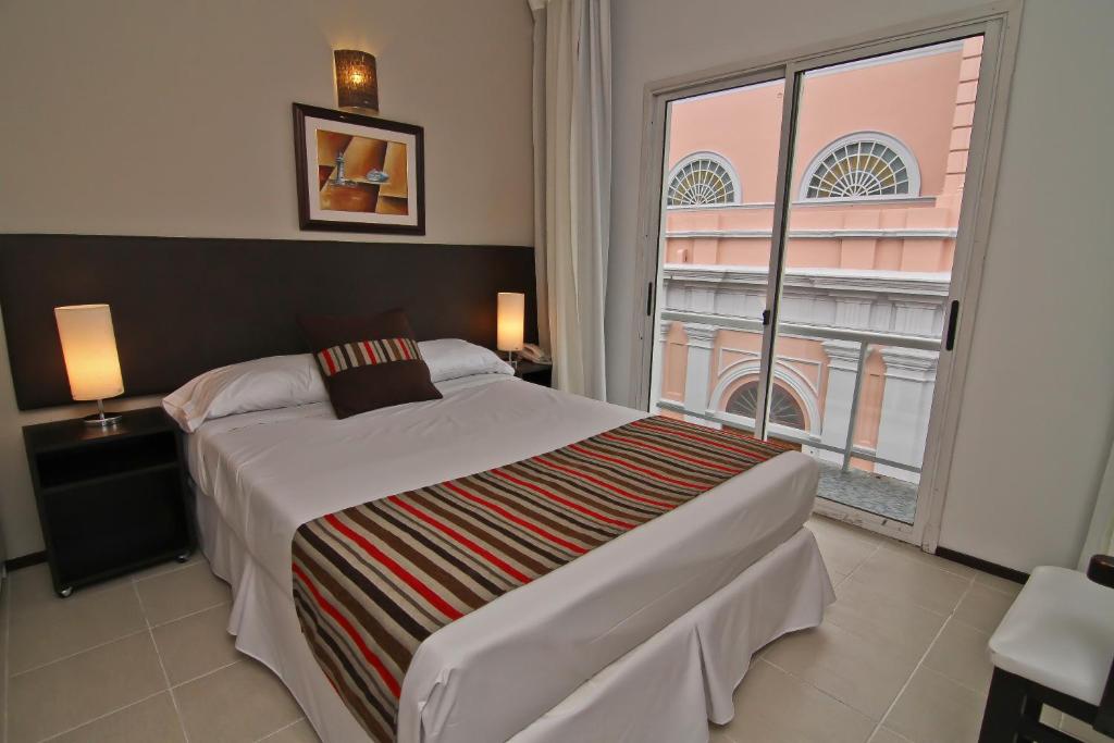 马尔多纳多De la Plaza Hotel的一间卧室设有一张大床和一个大窗户