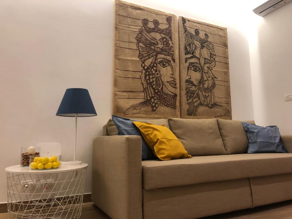 锡拉库扎Nesh House的客厅配有沙发和一幅女人画