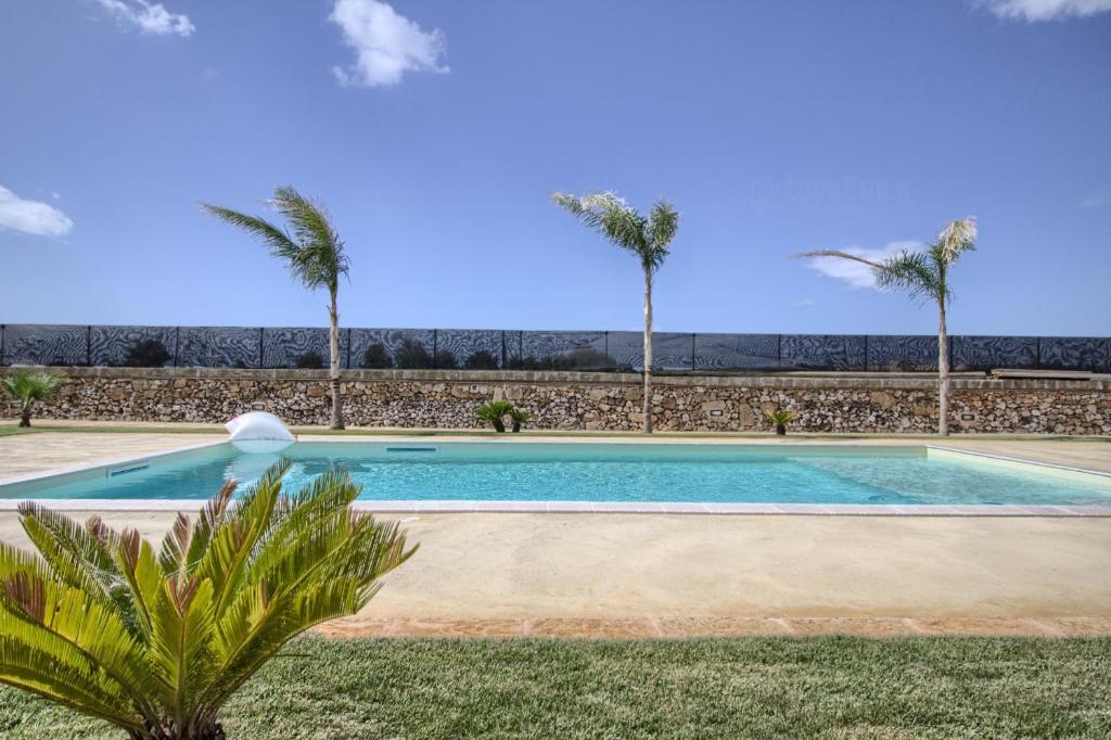 科尔萨诺Tenuta De Masi的一座棕榈树环绕的游泳池