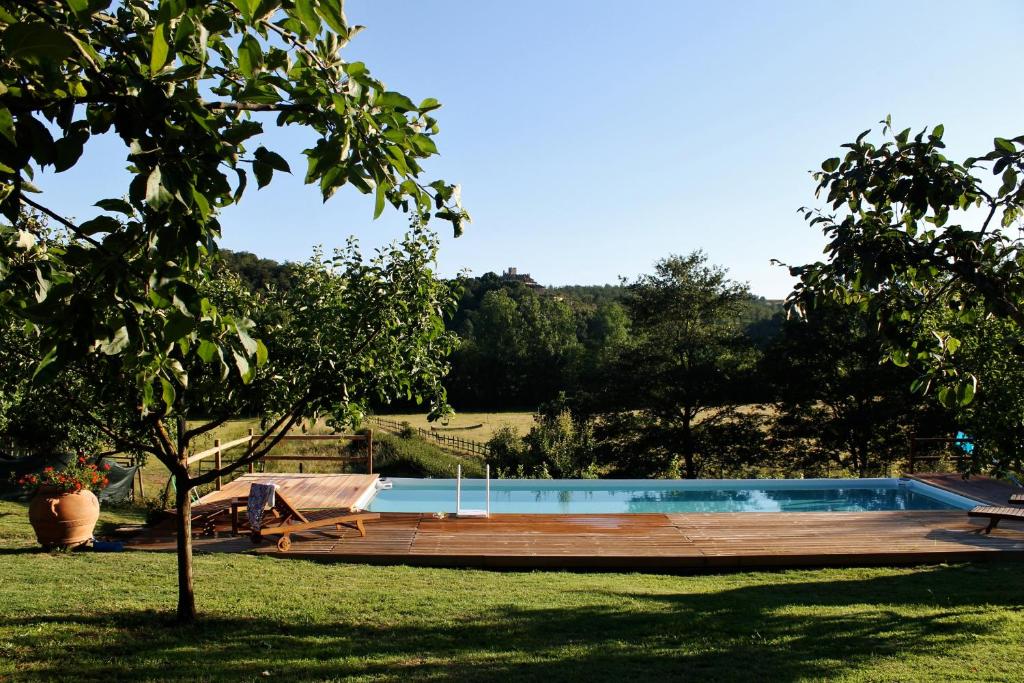 卡斯德尔诺沃贝拉登卡Centro Ippico Della Berardenga的一个带木甲板的庭院内的游泳池