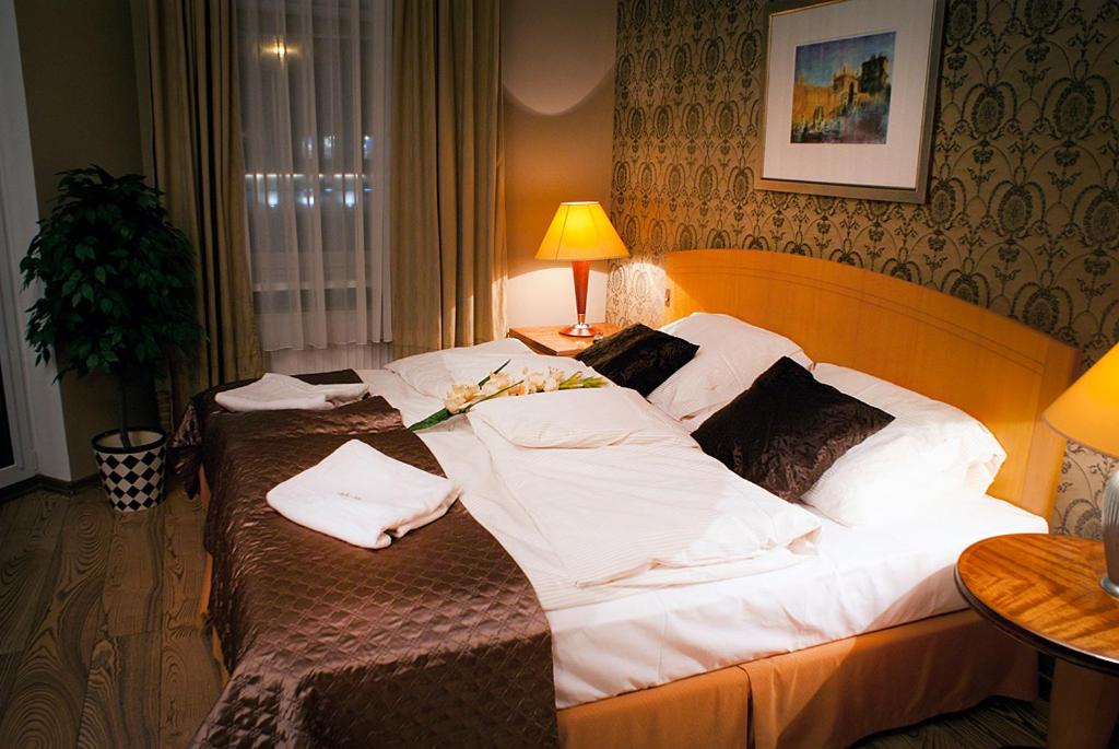 乔左维尔考普尔斯基MCM普拉斯酒店的酒店客房,配有两张带白色床单的床
