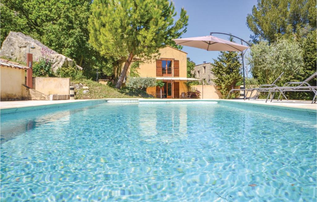 阿普特Stunning Home In Apt With 2 Bedrooms, Wifi And Outdoor Swimming Pool的一个带遮阳伞和房子的游泳池