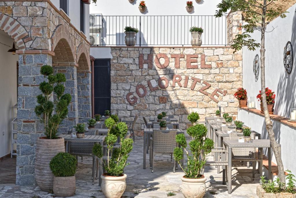 包内伊Hotel Goloritzé的石墙,带桌椅和植物