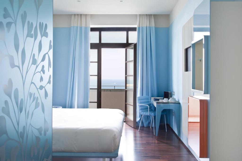 巴里JR Hotels Bari Grande Albergo delle Nazioni的一间卧室配有一张床、一张书桌和一个窗户。