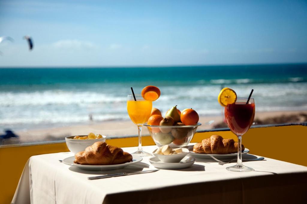 塔里法亚特维达酒店的一张桌子,上面有一盘食物和饮料在沙滩上