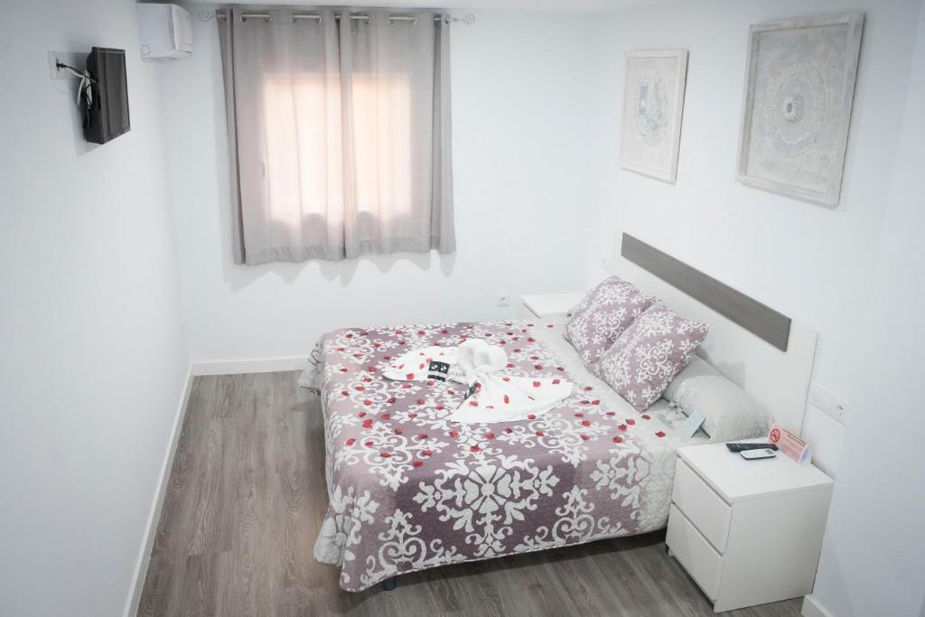 普拉森西亚格耶思科广场旅馆的一间小卧室,配有一张桌子和一张床铺