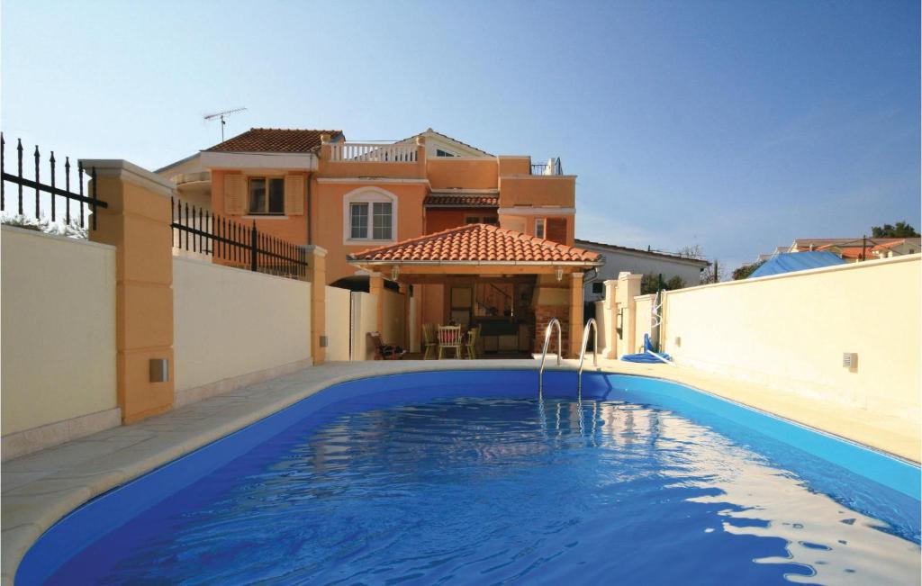 布罗达里卡Stunning Home In Brodarica With 6 Bedrooms, Wifi And Outdoor Swimming Pool的房屋前的游泳池