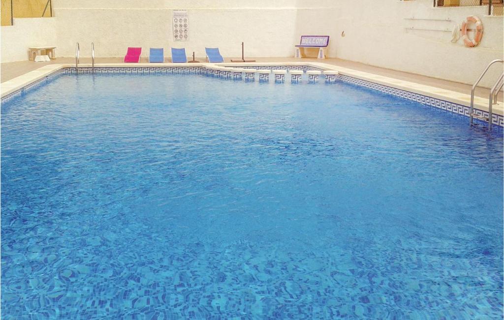 罗哈莱斯1 Bedroom Gorgeous Apartment In Rojales的大楼内一个蓝色的大型游泳池