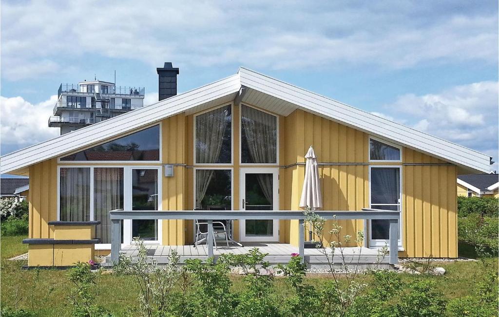 雷希林Nice Home In Rechlin With Sauna的黄色的房子,设有大窗户和雨伞
