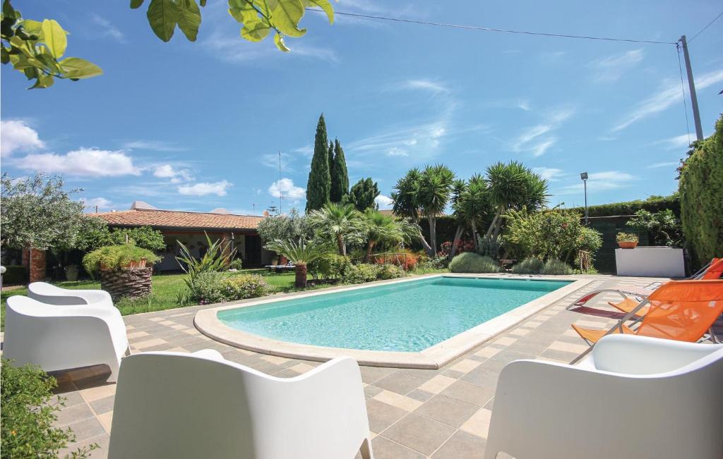 帕洛港Vento Di Mare的一个带白色椅子的庭院内的游泳池