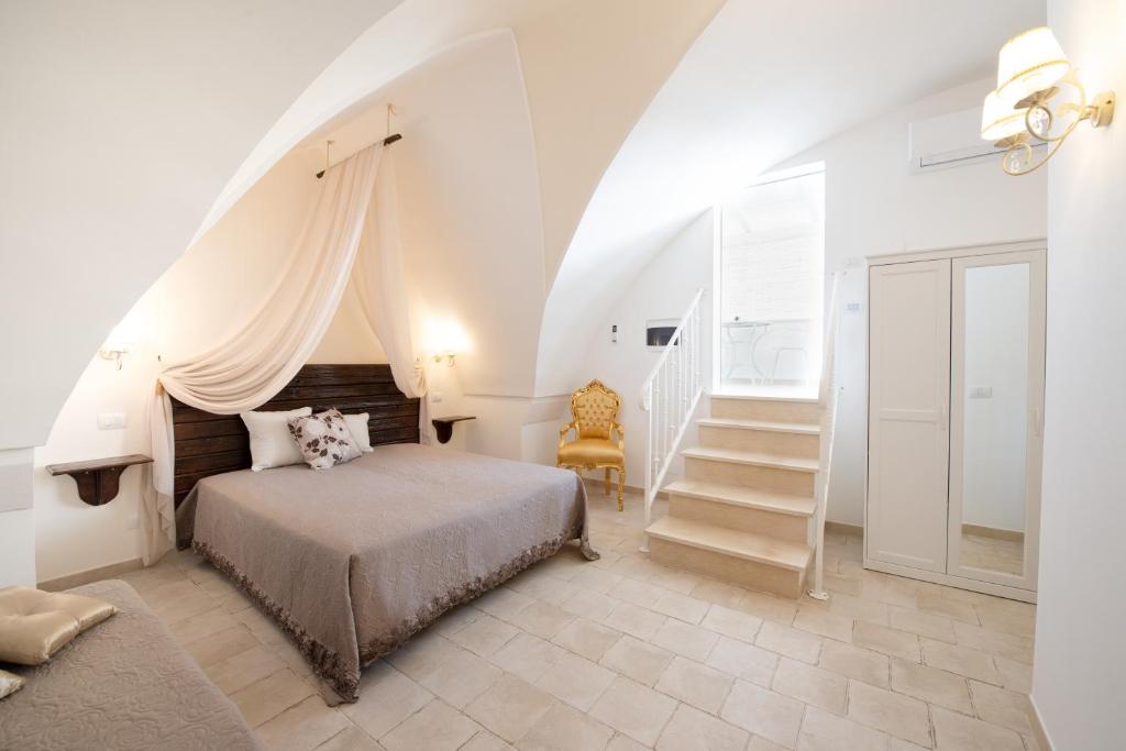 佩兹迪格雷科Il Vecchio Frantoio的一间白色的卧室,配有床和楼梯
