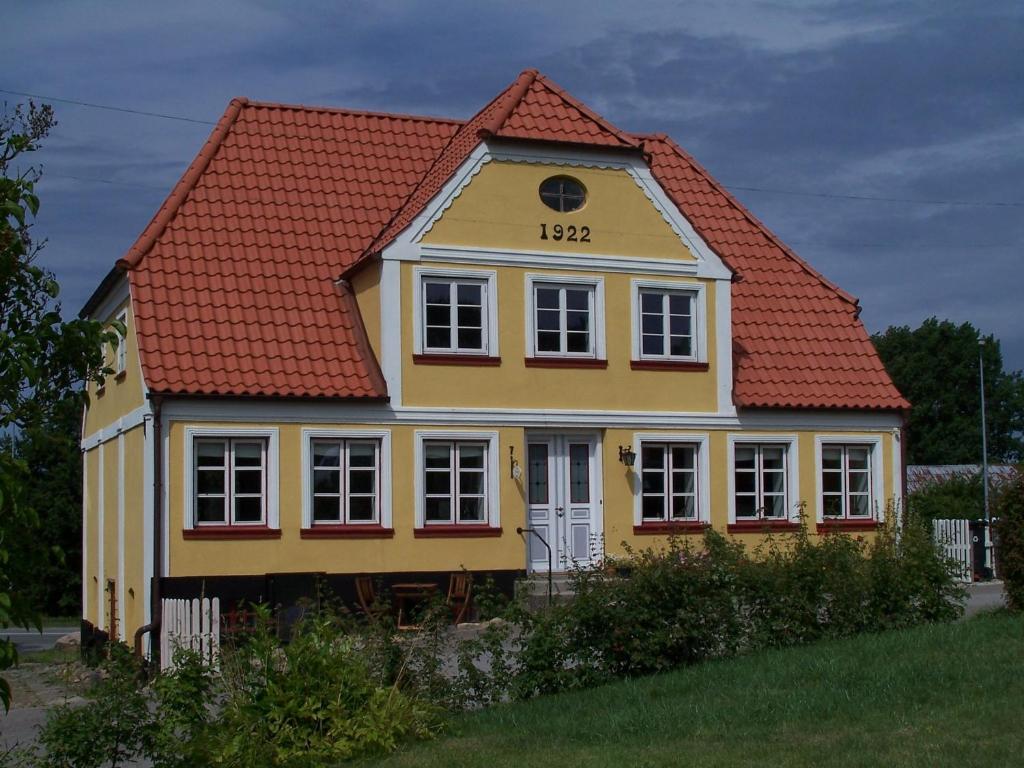 诺德堡莫勒哈森特斯经济型酒店（客房&早餐）的黄色的房屋,有红色的屋顶