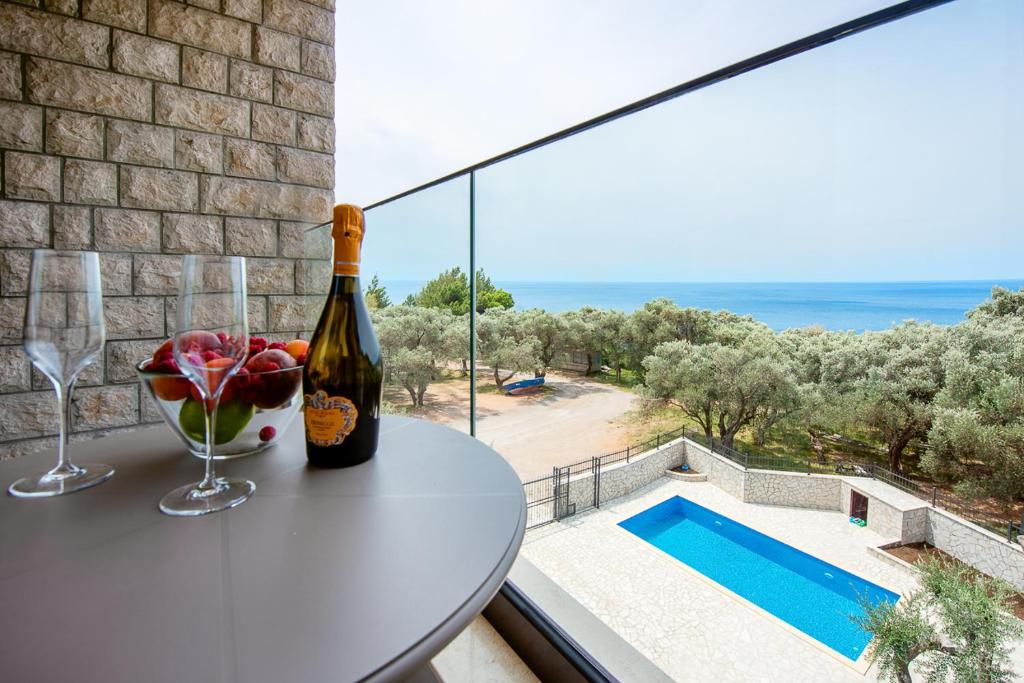 斯韦蒂·斯特凡Adria lux apartmens 2的阳台上的桌子上放着一瓶葡萄酒,享有风景。