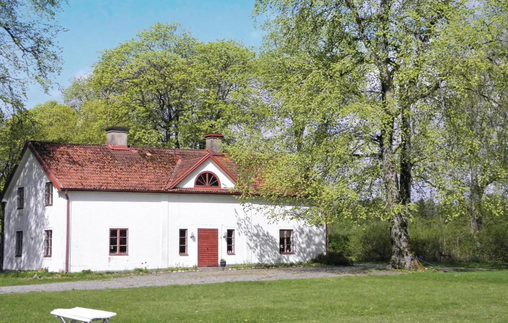 韦特兰达4 Bedroom Gorgeous Home In Vetlanda的白色的房子,有红色的屋顶和一棵树